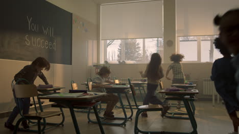 escolares positivos corriendo en el aula después de las vacaciones en la escuela primaria