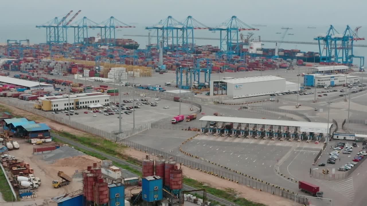 Workers move cargo and trucks transport goods at Tema Port in Accra, Ghana
