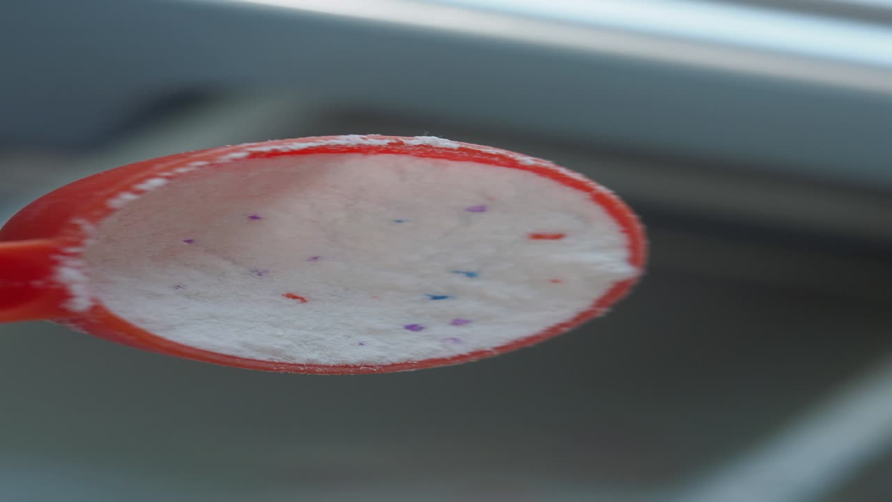 detergente para lavar ropa en polvo en una cuchara medidora