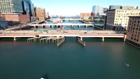 fort point channel over boston harbor, aerial following cars to right during day