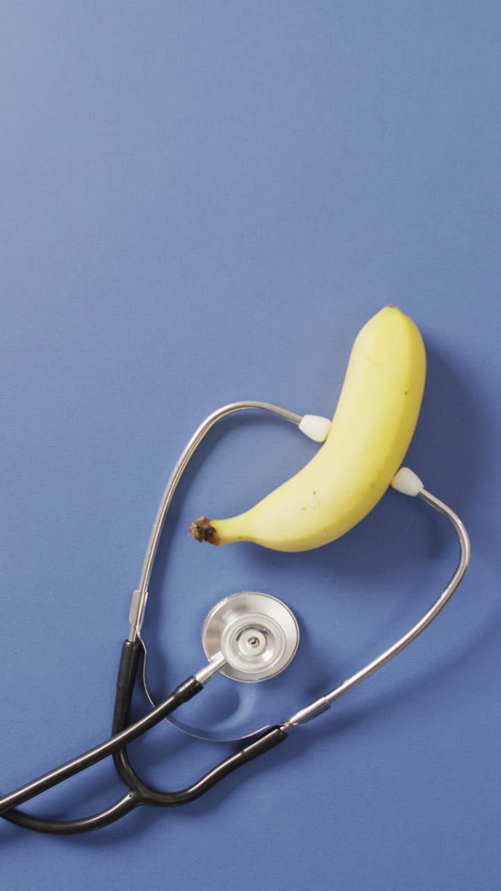Video verticale di stetoscopio e banana su sfondo blu