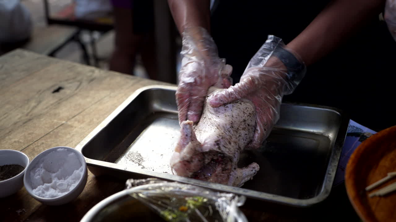 Person's Hands Massaging Whole Chicken With Spices On Tray For Roasting. - closeup shot