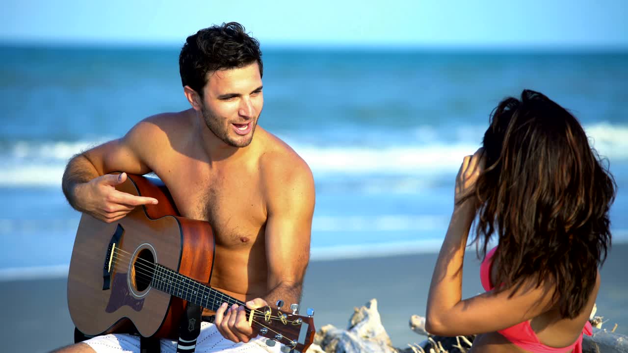 mujer latinoamericana fotografiando hombre caucásico tocando la guitarra