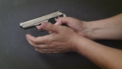 hand chambers gun and racks pistol slide, close-up