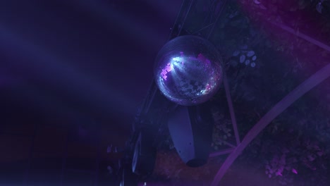 close up of a disco ball reflecting purple and blue lights during a lively party atmosphere