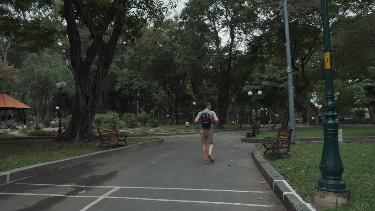 Man Walking Through a City Park