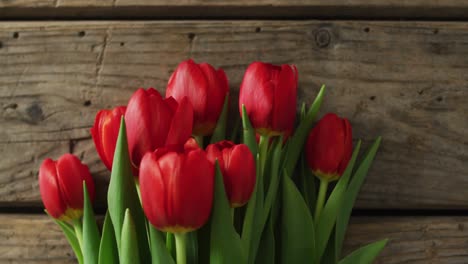 ramo de tulipanes rojos sobre un fondo de madera en el día de san valentín