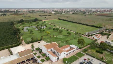 aerial view of the masía de las estrellas next to its golf course