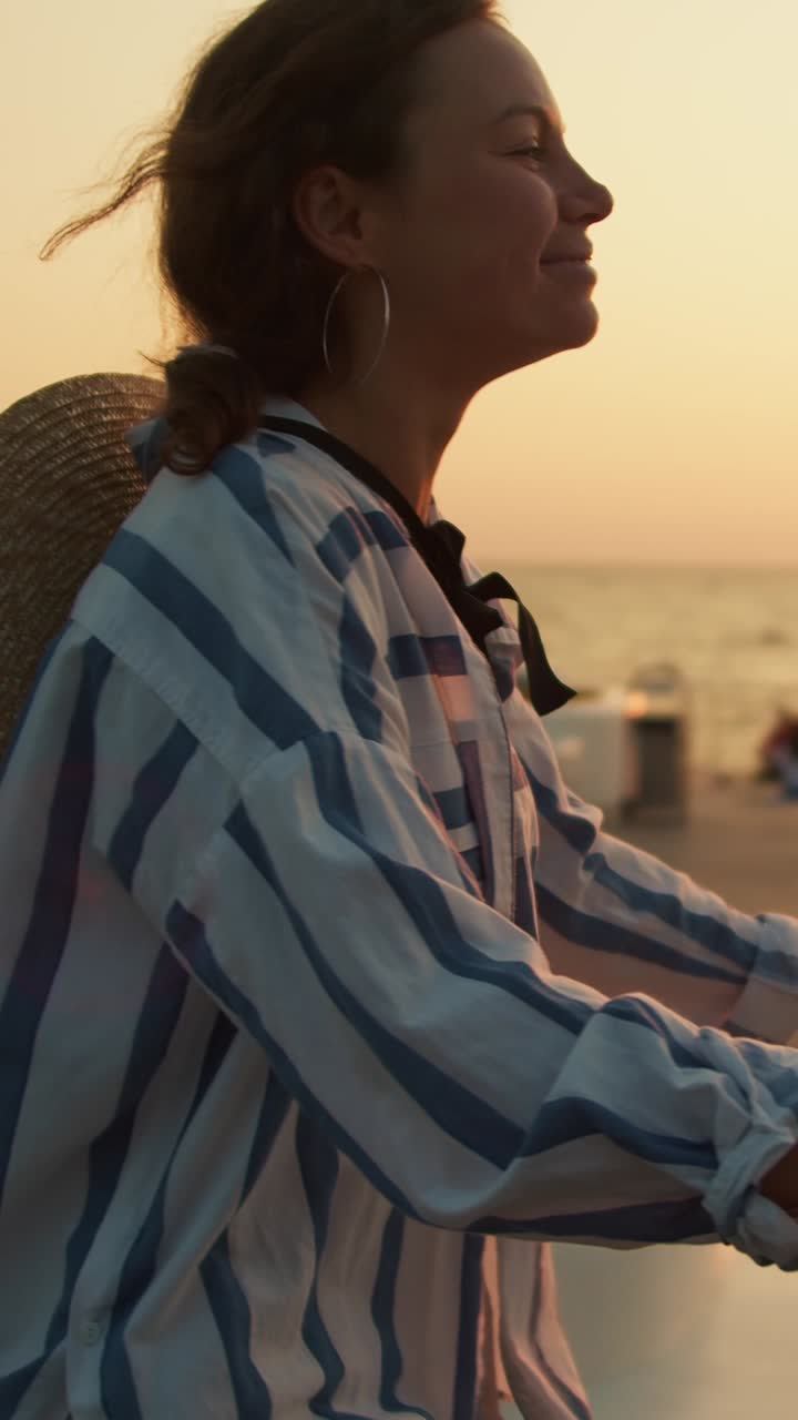 Woman on bicycle at sunrise by the ocean