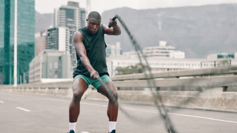 man working out with a battle rope in an urban setting