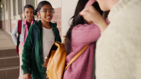 students greeting teacher in school hallway