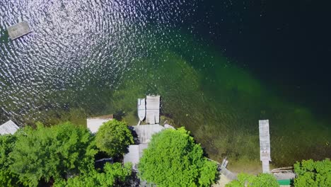uhd drone reveal shot of an aluminum boat moored to a dock on a deep lake in ontario canada