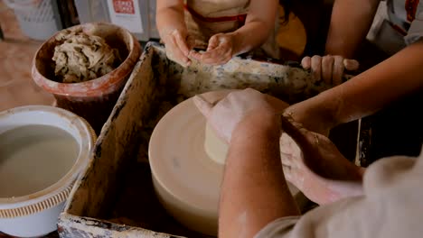 potter showing how to work with ceramic in pottery studio