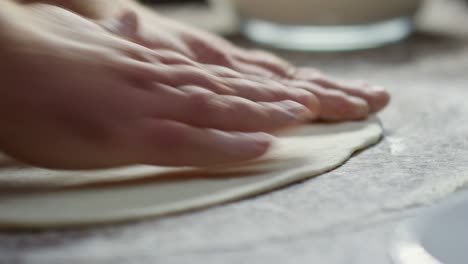 chef shaping dough for pizza