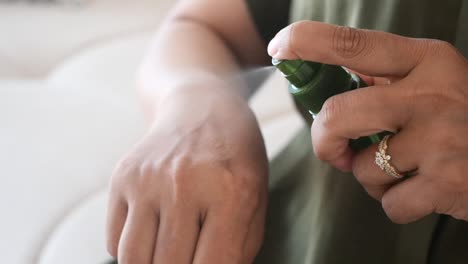 mujer aplicando spray en su brazo