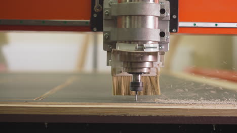 Wood-lathe-machine-cuts-out-line-in-plywood-sheet-in-shop