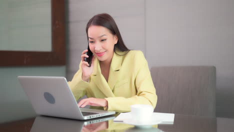 successful young asian girl in a modern office in yellow suite