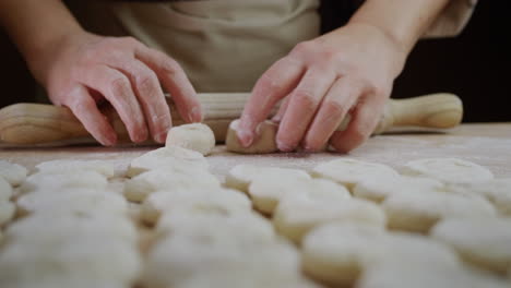 a skillful baker rolls out dough for baking. his movements are fast and professional