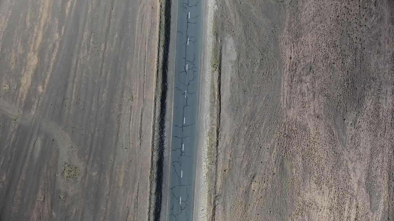 disparo aéreo de un avión no tripulado de un coche conduciendo en una carretera desértica desde arriba