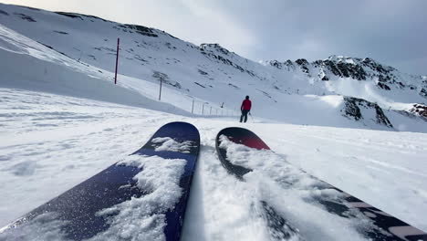 Low-angle-POV-slowly-skiing-down-a-flat-ski-slope-on-a-ski-resort