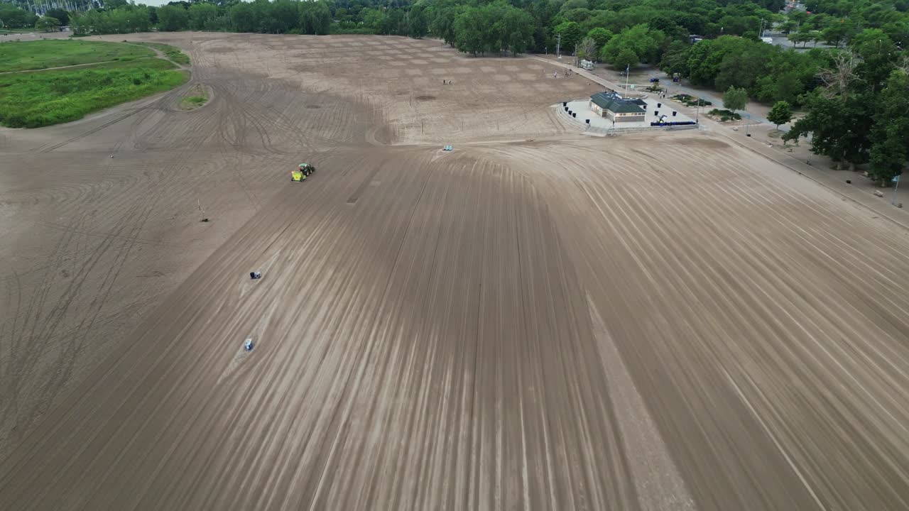 vista aérea de una vasta tierra cultivada con tractor en funcionamiento