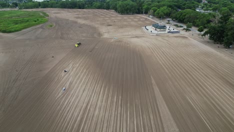 Vista-Aérea-De-Una-Vasta-Tierra-Cultivada-Con-Tractor-En-Funcionamiento