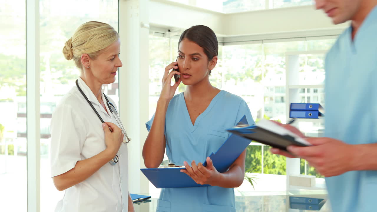 Doctors holding clipboard and having a phone call