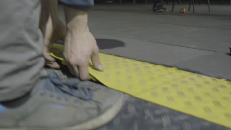 installing yellow plastic floor tiles