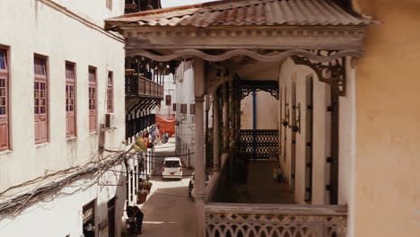 View-of-Zanzibar-Stone-Town-old-narrow-street-with-old-wooden-balconies-and-parked-cars