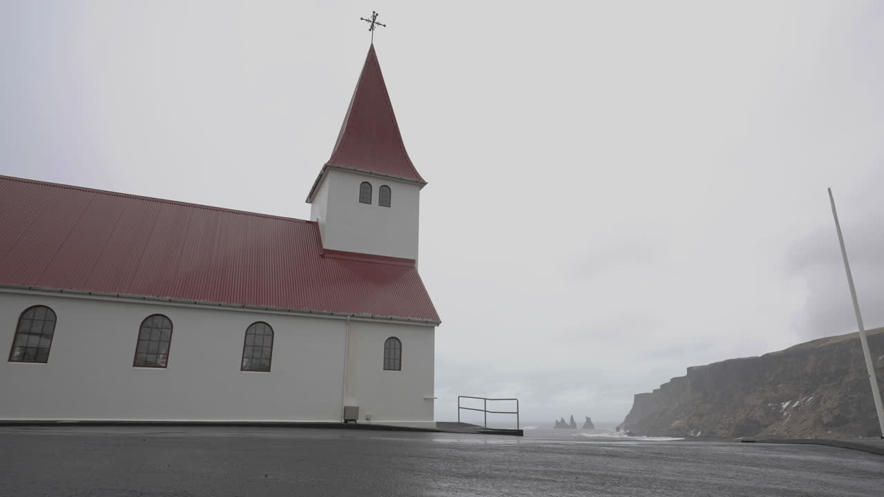 V&iacute;k &iacute; M&yacute;rdal Village Church on Hill Above Coastline of Iceland on Cloudy Day