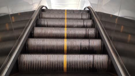 escalator steps moving upward inside modern building. perfect for transport, travel, shopping mall, metro and urban lifestyle footage