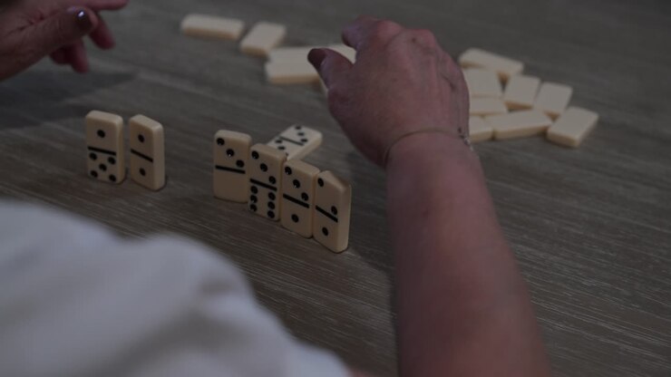 elderly woman playing dominoes late at night