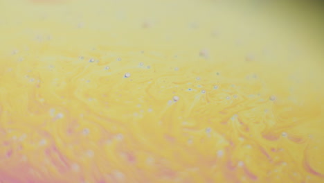 macro shot of a yellow liquid changing the color to blue