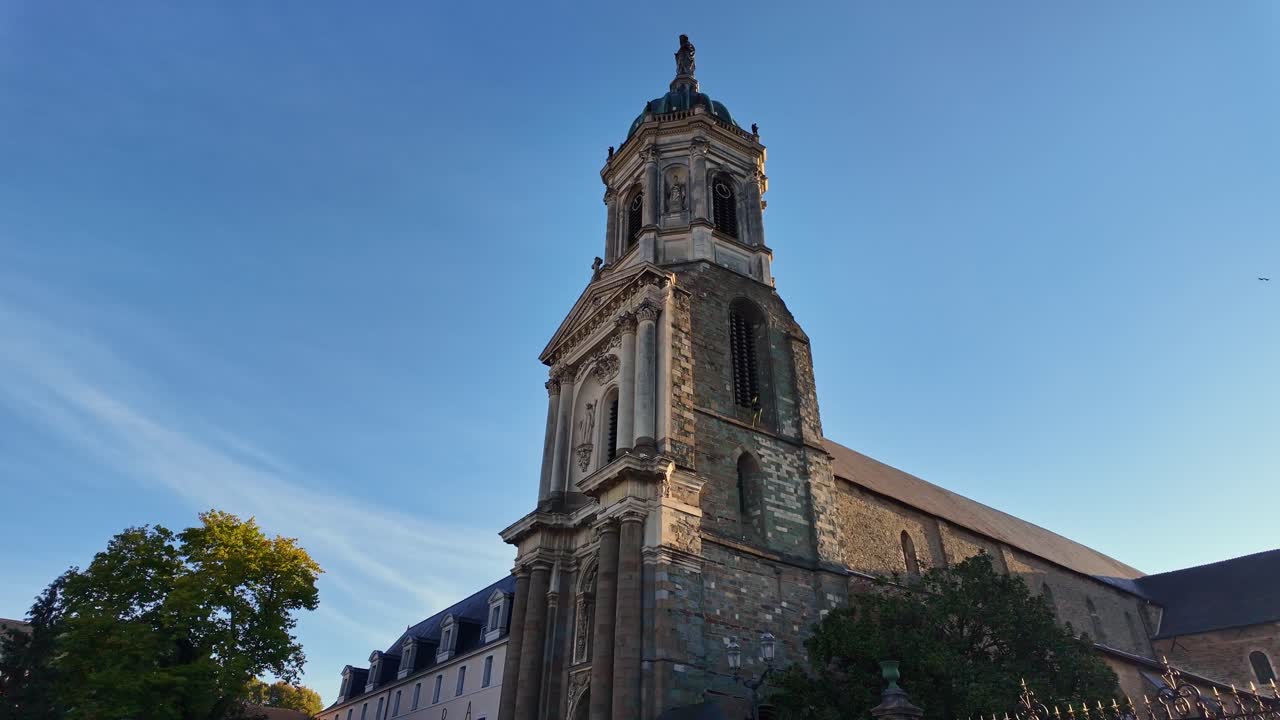 Ground shot moving forward toward Notre-Dame en Saint-Melaine Church in Rennes, filmed in low angle with a lamp post and clear blue sky