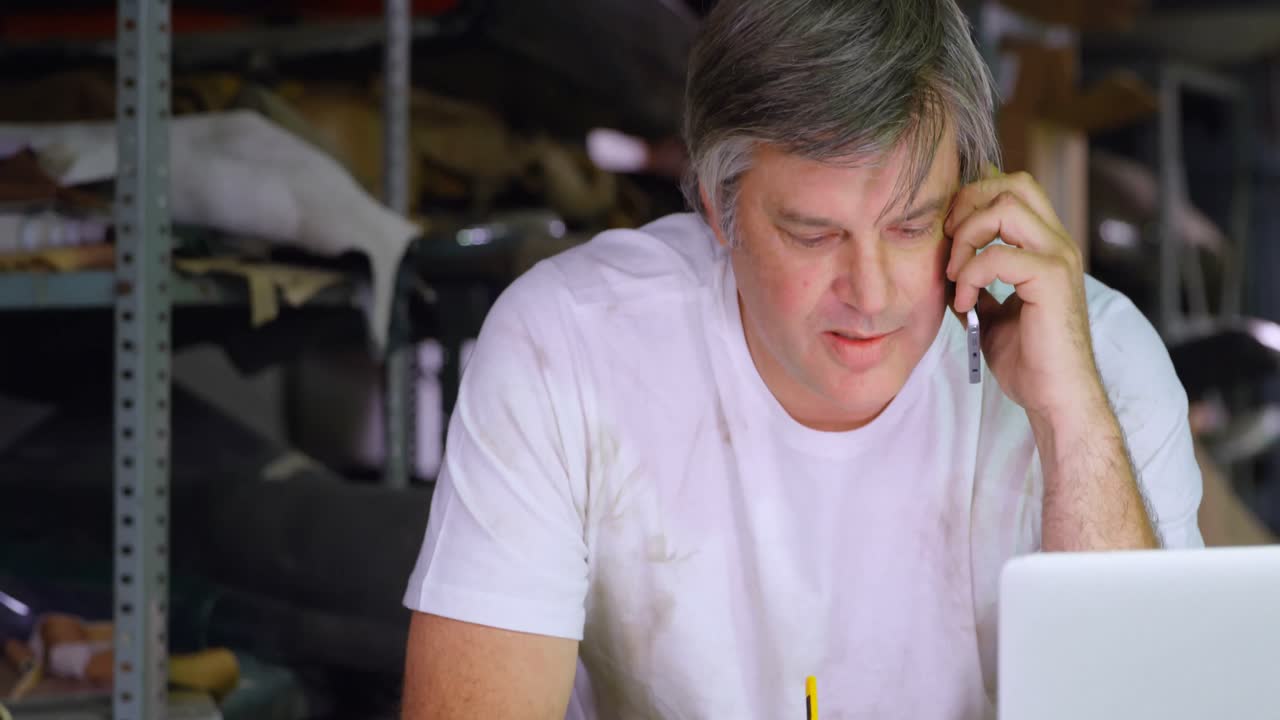 노트북 4k를 사용하는 동안 휴대 전화로 이야기하는 남성 메카닉