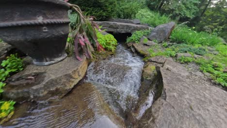 amazing view of a triple tier waterfall flowing through a vibrant flower garden