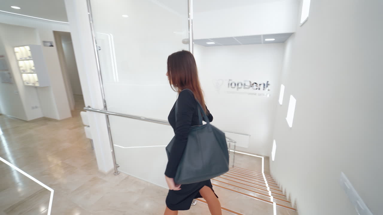 Woman stepping up stairway. Woman moving upstairs in modern building
