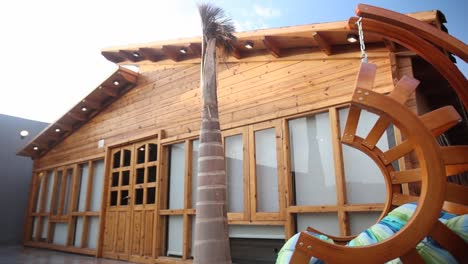 Close-up-walking-backwards-from-rocking-chair-revealing-wooden-house-facade