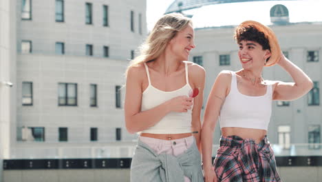 dos mujeres caminando y riendo en la ciudad