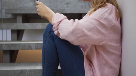 Side-view-of-woman-using-smartphone-in-hotel