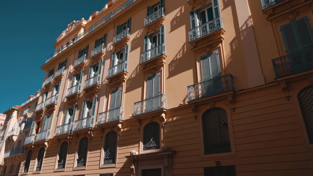 Exterior view of an orange building with many windows and balconies under a blue sky