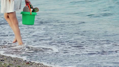 legs of young woman stepping on sand. barefoot girl at the sea shore. summer vacation holiday. slow motion
