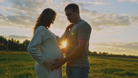 pregnant couple at sunset