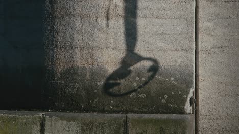 The-shadow-of-an-old-anchor-rope-swaying-on-a-concrete-pillar