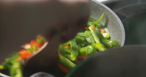 frying and mixing colorful vegetables