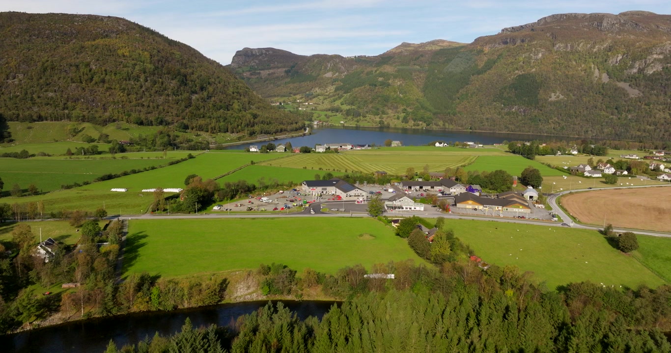 Ländliche, malerische Sommerstadt Aardal in Norwegen mit grünen Feldern und Bergen im Hintergrund, etablierende Luftaufnahme