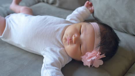 a wiggling newborn baby laying on a couch