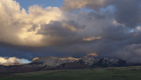 Gloomy-Sky-With-Sunset-Clouds-Crawling-Over-Snow-Rock-Mountains