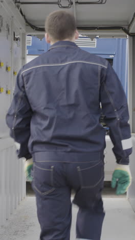 worker inspecting or loading compressed gas cylinders on a truck trailer