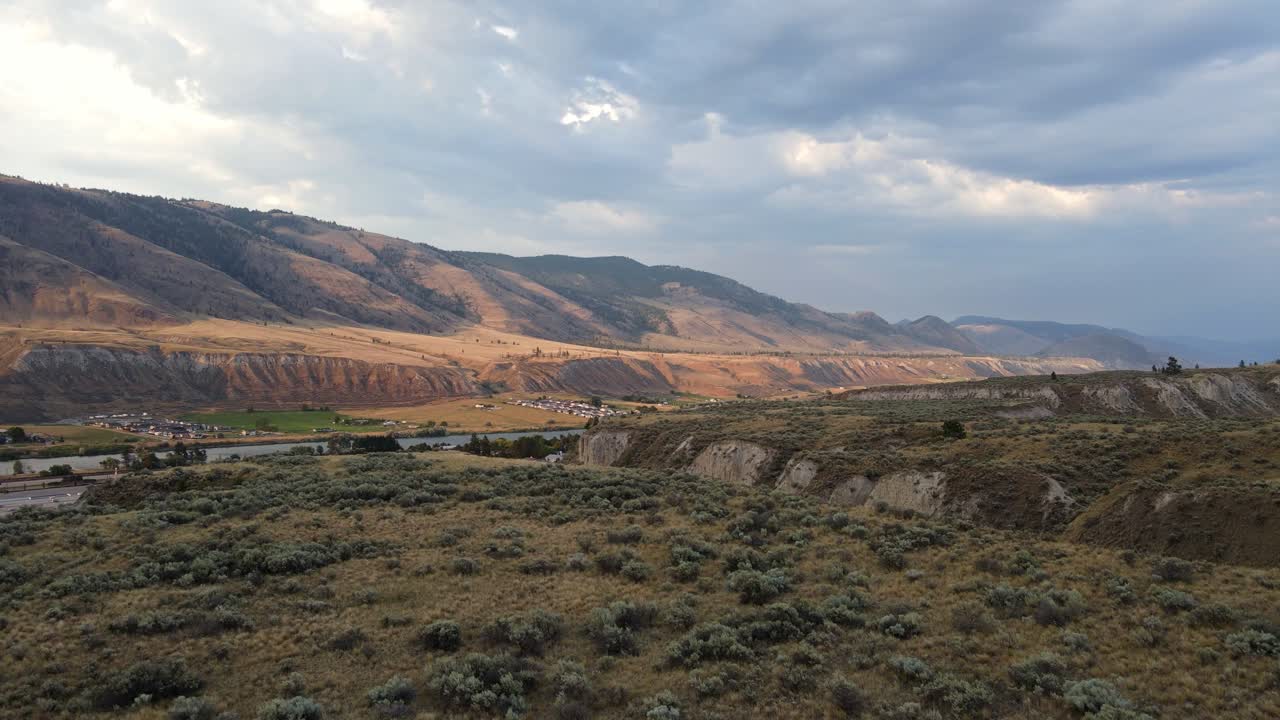 Vasti e aridi paesaggi montuosi dell'Okanagan illuminati dal sole della sera.